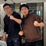 こぶしを握ってポーズをとる男性2人