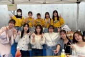 屋台のテントの下でピースをする女子バレーボール部の部員たち