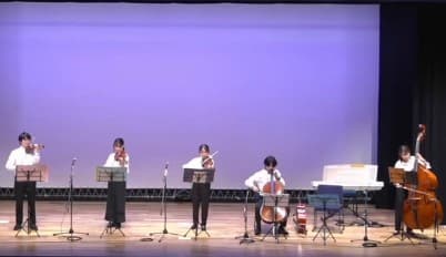 ステージで弦楽器を演奏する5人の奏者の写真