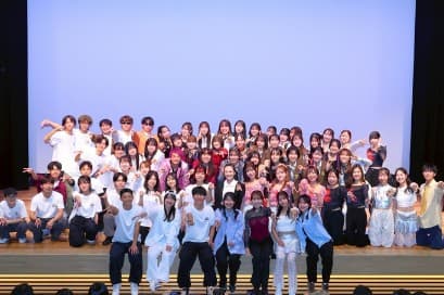 講堂の舞台に並んだ NMU DANCE CLUB の部員の集合写真